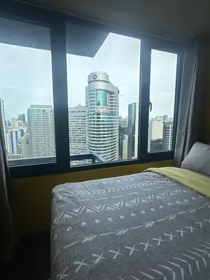 a bedroom with a view of a city from a window at Sunbeam - Lush Residence in Manila