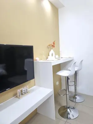a living room with a tv and a white counter at MP shore 1 c2 unit1583 in Manila