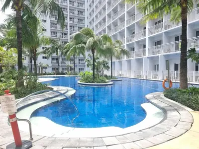 a swimming pool in the middle of a building with palm trees at MP shore 1 c2 unit1583 in Manila