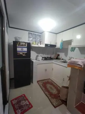 a small kitchen with white cabinets and a black refrigerator at Affordable 2-Storys Whole house in Imus in Imus