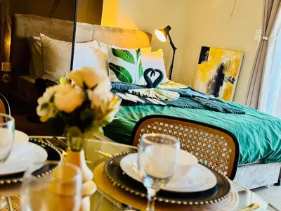 a bedroom with a bed and a table with plates and glasses at Cozy unit with balcony Netflix walk to Venice Mall in Manila