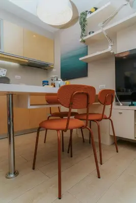 a kitchen with four chairs and a table at Chic Eastwood City Studio w Pool and Gym Access in Manila