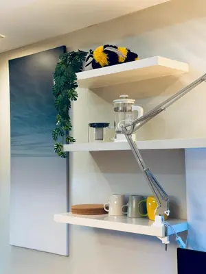a shelf with cups and mugs on it at Chic Eastwood City Studio w Pool and Gym Access in Manila