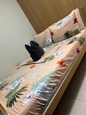 a bed in a room with flowers on it at Shell Residences Moa AJ in Manila
