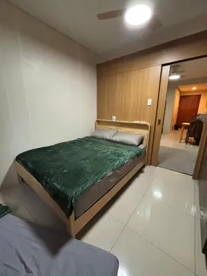 a bedroom with a bed with a green blanket on it at Lundayan Staycation in Manila