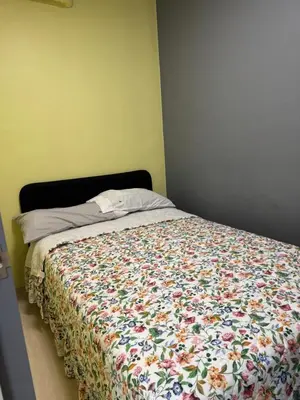 a bed with a floral comforter in a bedroom at Jopays 2BR, Brand New Unit in Cainta