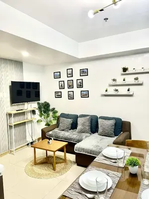 a living room with a couch and a table at AzurestaycationbyGS in Manila
