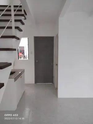 a white room with a staircase and a door at One Cenon place in Postema