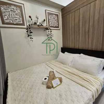 a teddy bear sitting on a bed with a book at 1BR Pool View Balcony Near MOA Shore 2 Tower 1 in Manila