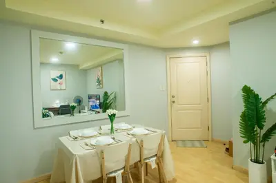 a dining room with a table and a mirror at Nature Serenity Suites 2BR Makati in Manila