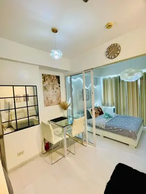 a bedroom with a bed and a desk and a table at Azure Rio East 221 in Manila