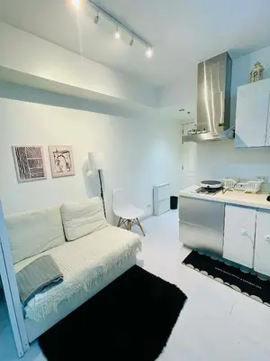 a white room with a bed and a kitchen at Azure Rio East 221 in Manila