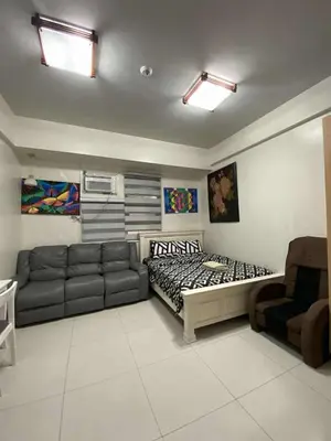 a living room with a bed and a couch at Vienna Condotel in Manila