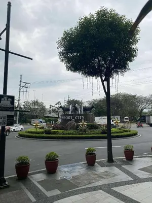 a tree on the side of a street with a sign at Vienna Condotel in Manila