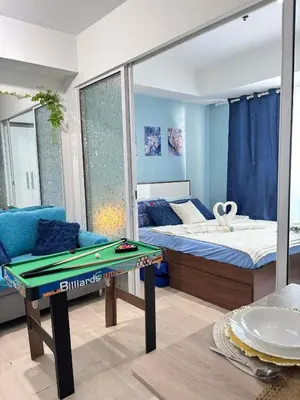 a room with a bed and a table with a mirror at The Session Azure in Manila