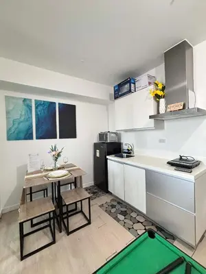 a small kitchen with a table and a pool in it at The Session Azure in Manila