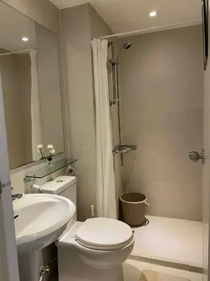 a bathroom with a toilet and a sink and a shower at Azure Staycation in Manila