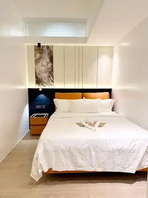 a bedroom with a large white bed with white sheets at Venice Luxe Cozy 1 BedRoom, Pool, Netflix, Kitchen, Canal Mall Access in Manila