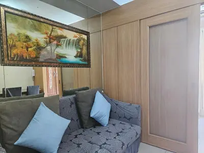 a living room with a couch and a painting on the wall at Shell Low Floor Amenity Pool View with Balcony MOA Shell004 in Manila