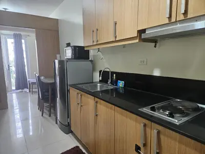 a kitchen with a sink and a refrigerator at Shell Low Floor Amenity Pool View with Balcony MOA Shell004 in Manila