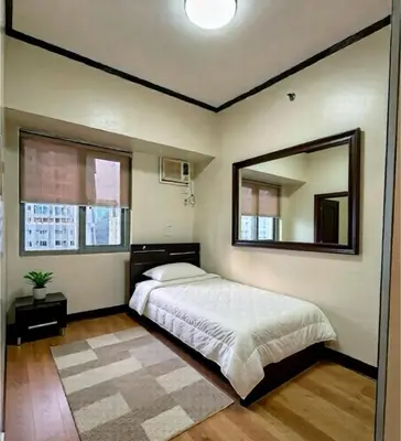 a bedroom with a bed and a large mirror at 2 Bedroom at The infinity Condominium at BGC in Manila