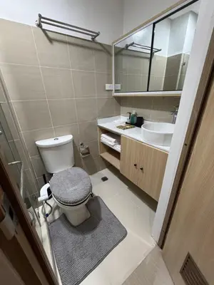 a bathroom with a toilet and a sink at Premium Studio at Shore Residences in Sampong