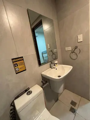 a bathroom with a sink and a toilet and a mirror at Sunnyplace Residences 2 BR Near NAIA Airport in Manila