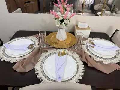 a table with two plates and a vase of flowers at Casa Feliz Staycation in Manila