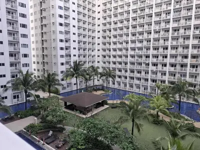 an aerial view of a large building with palm trees at Amenity Pool View 1 BR balcony MOA SMX Ikea Shore002 in Manila