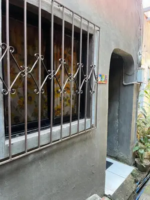 a window with bars on it with a bunch of food at Liza residence in Manila