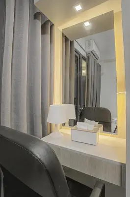 a mirror and a table with a lamp and a chair at Cozy 1BR Balcony with Pool View Plus Free Parking in Manila