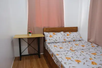 a bed with a nightstand next to a bed with autumn leaves at Idesia Dasmarinas NEW 3BR home with wifi & parking in Dasmariñas