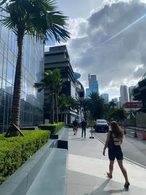 a woman walking down a sidewalk in a city at AZ Sweet home 2BR A Venue Residences Poblacion Makati in Manila
