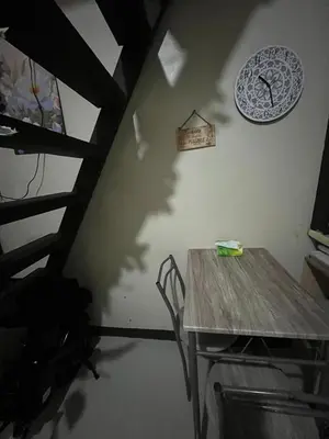 a dining room with a table and a clock on the wall at Liza homestay in Manila
