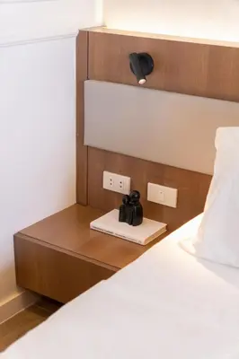 a room with a bed with a night stand next to it at Modern Condo at Park McKinley West with Wi-Fi and Washer in Manila