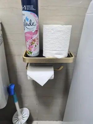 a bathroom with a shelf with towels and toilet paper at Zen 2 Shore A Residences in Manila