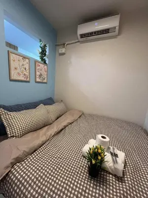 a bedroom with a bed with flowers and a fan at Chic Urban Escape at S Residence Tower 3 in Manila