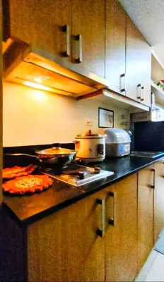 a kitchen with a counter top with some food on it at JandG MOA Staycation Amenity view at Shell residence in Manila