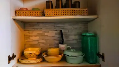 a shelf with bowls and plates and baskets on it at JandG MOA Staycation Amenity view at Shell residence in Manila