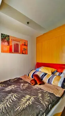 a bedroom with a bed with a red headboard at JandG MOA Staycation Amenity view at Shell residence in Manila
