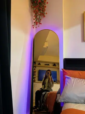 a woman taking a picture of herself in a mirror at The Warm Suite By ANC at Azure in Manila