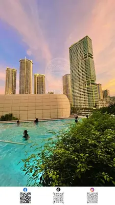 a group of people swimming in a pool in a city at 3 min to Rockwell City View Pool Parking in Manila