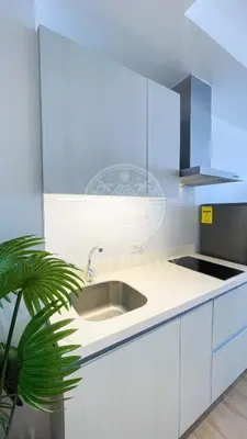 a white kitchen with a sink and a plant at 3 min to Rockwell City View Pool Parking in Manila