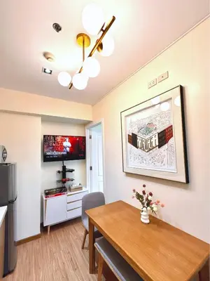 a dining room with a table and a kitchen at Azure Urban Resort 1BR-2BR St Tropez in Manila