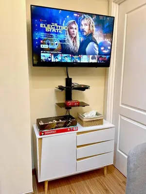 a flat screen tv on a wall above a dresser at Azure Urban Resort 1BR-2BR St Tropez in Manila