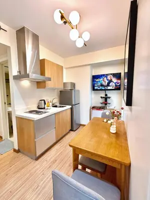 a kitchen with a wooden table and a dining room at Azure Urban Resort 1BR-2BR St Tropez in Manila