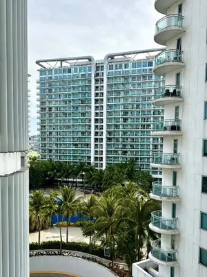 a large building with palm trees in front of it at Azure Urban Resort 1BR-2BR St Tropez in Manila