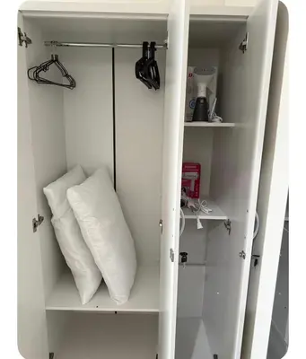 a white cabinet with two pillows on it at Staycay at SRESIDENCES in Manila