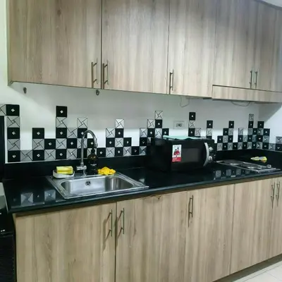 a kitchen counter with a sink and a microwave at Shore Recidences Mall Of Asia Cullen in Manila