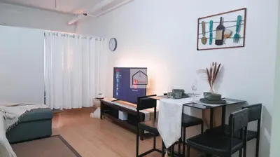 a living room with a dining room table and a table and chairs at Aludia's Dreamplace in Manila